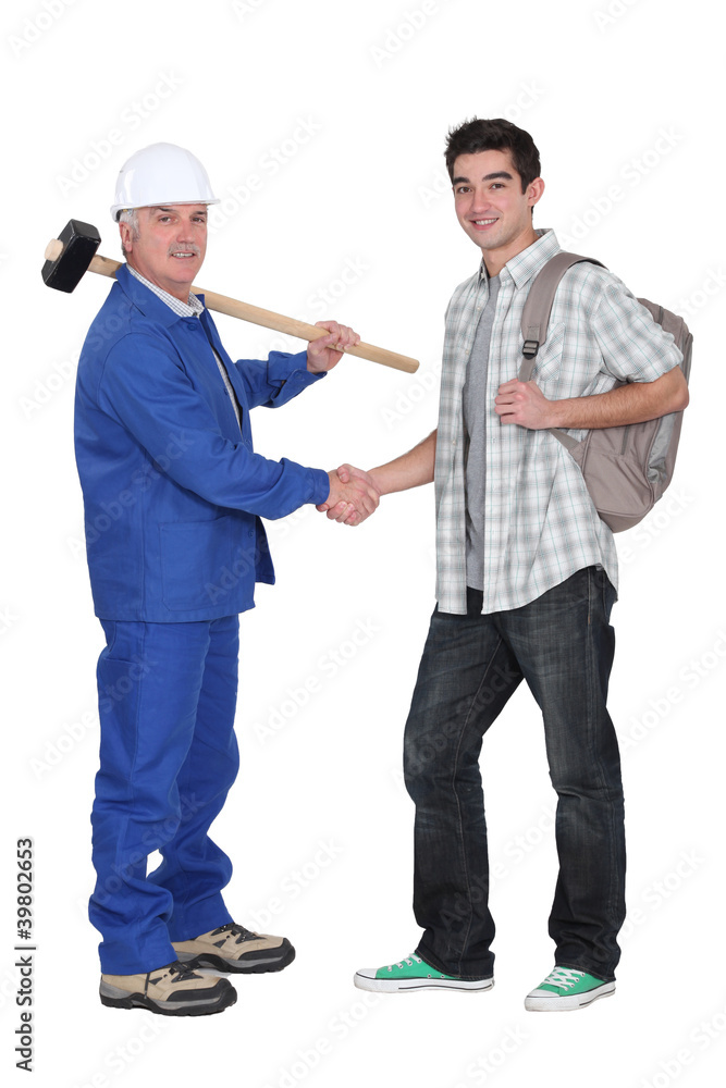 mature craftsman shaking hands with apprentice mature craftsman shaking hands with apprentice