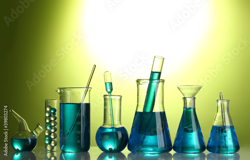Test-tubes with blue liquid on green background