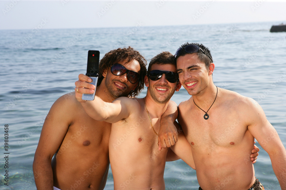 Young men taking pictures at the beach Young men taking pictures at the beach