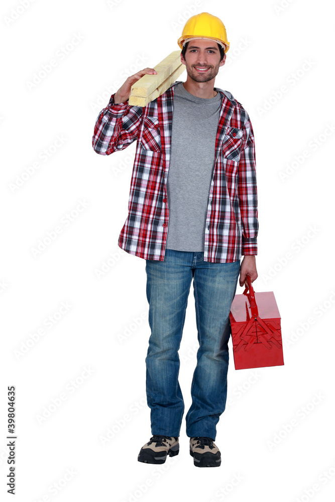 Workman carrying timber and a toolbox Workman carrying timber and a toolbox