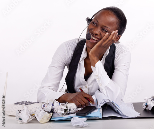 Young South African woman overwhelmed by work but smiling photo