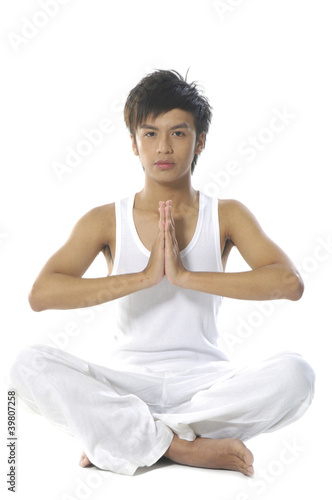 Young man practicing yoga in white clothes
