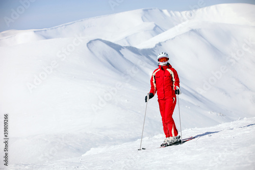 Female skier standing on mountain slope