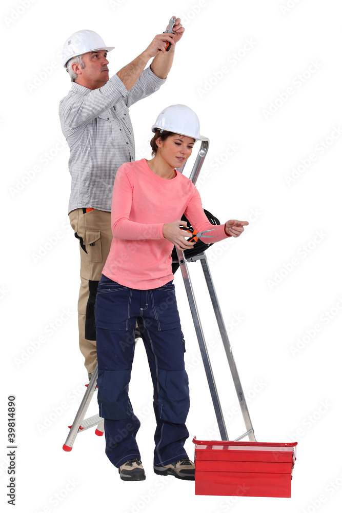 electrician and female apprentice working together electrician and female apprentice working together