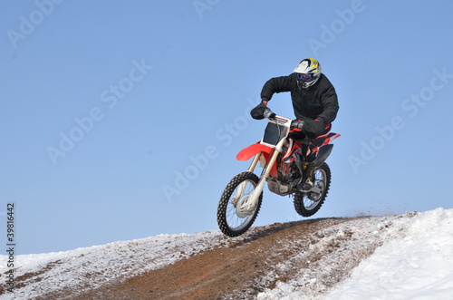 Motocross racer flying down the mountain