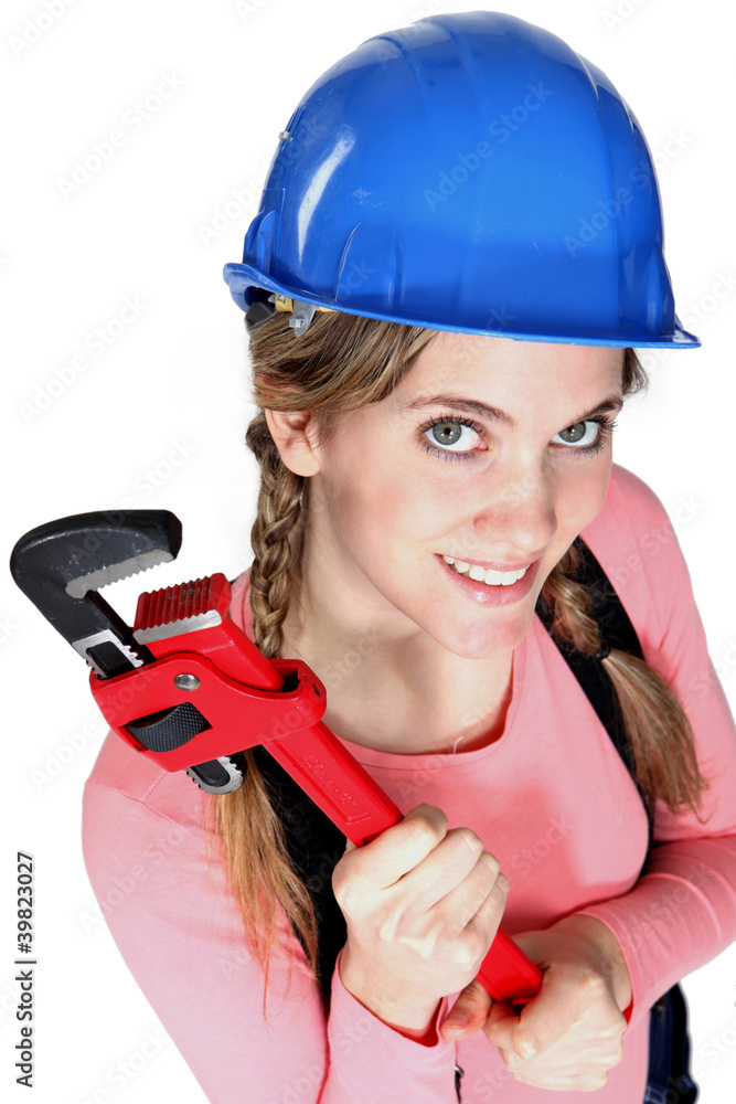 A female construction worker holding a wrench. A female construction worker holding a wrench.