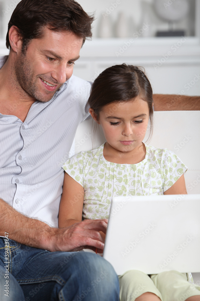 Father and daughter using computer together