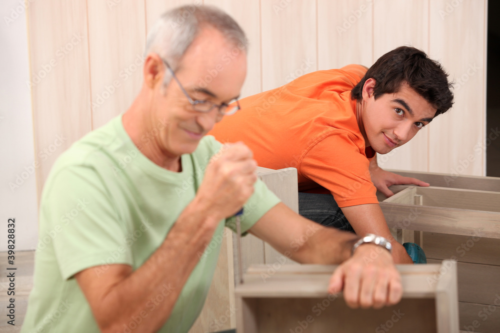 Grandfather helping grandson with the furniture Grandfather helping grandson with the furniture