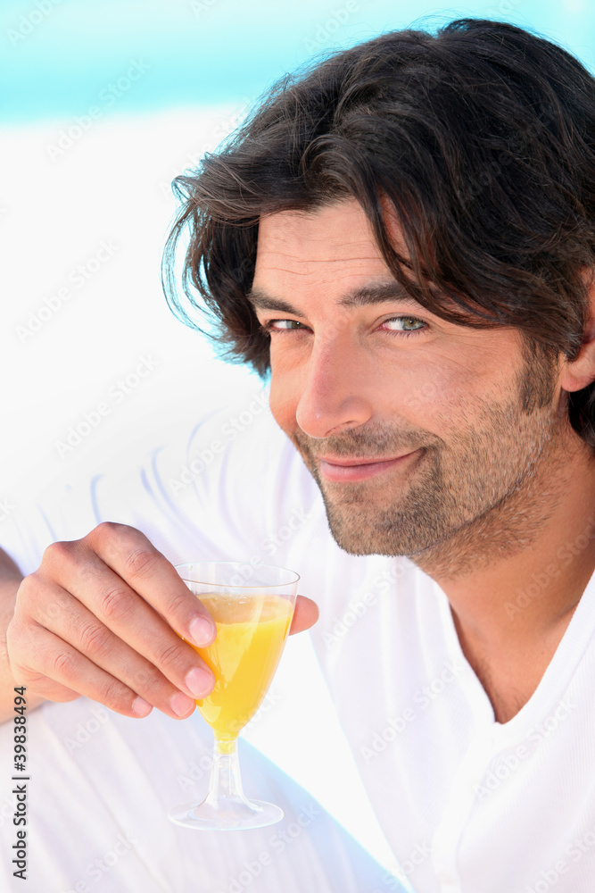 Dark haired man drinking orange juice Dark haired man drinking orange juice