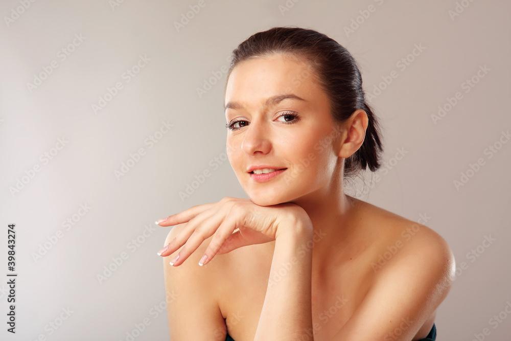 A portrait of a beautiful woman isolated on grey background A portrait of a beautiful woman isolated on grey background