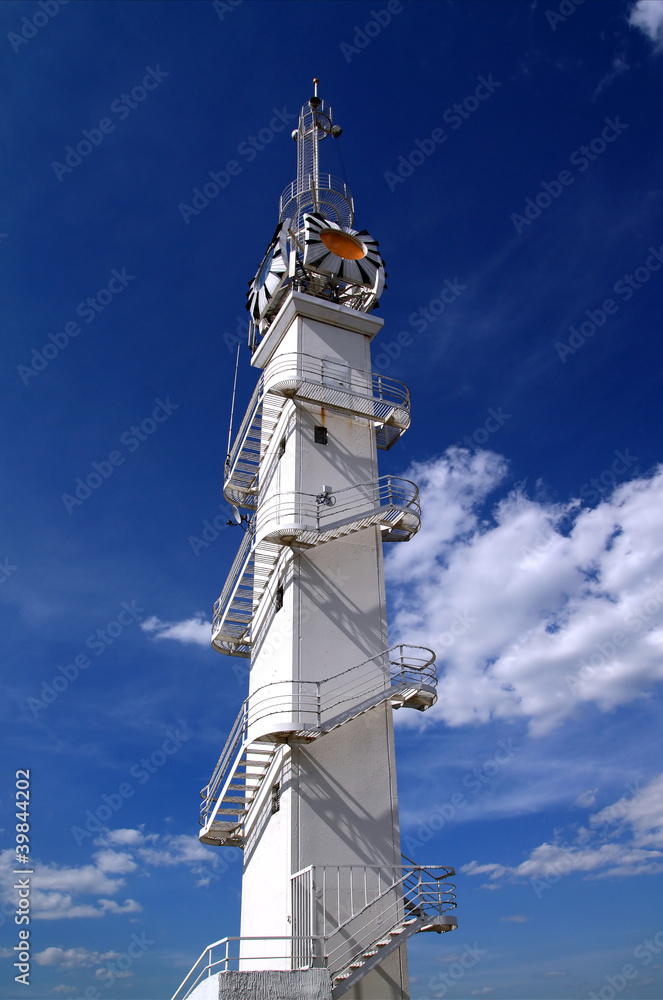 white lighthouse on cloudy background