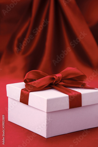 Little white present with a red bow on red background