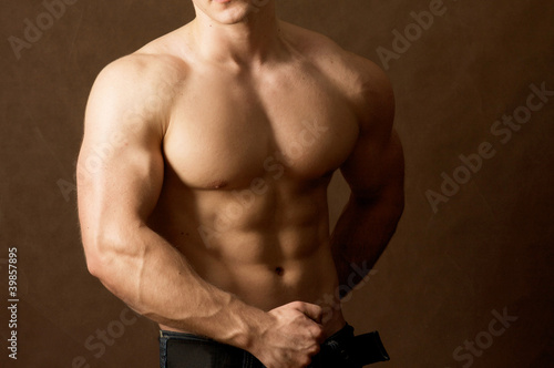 Obraz na plátně Muscular man , isolated on brown background