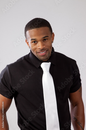 black man in black shirt and white tie smiling at camera Stock Photo Adobe Stock