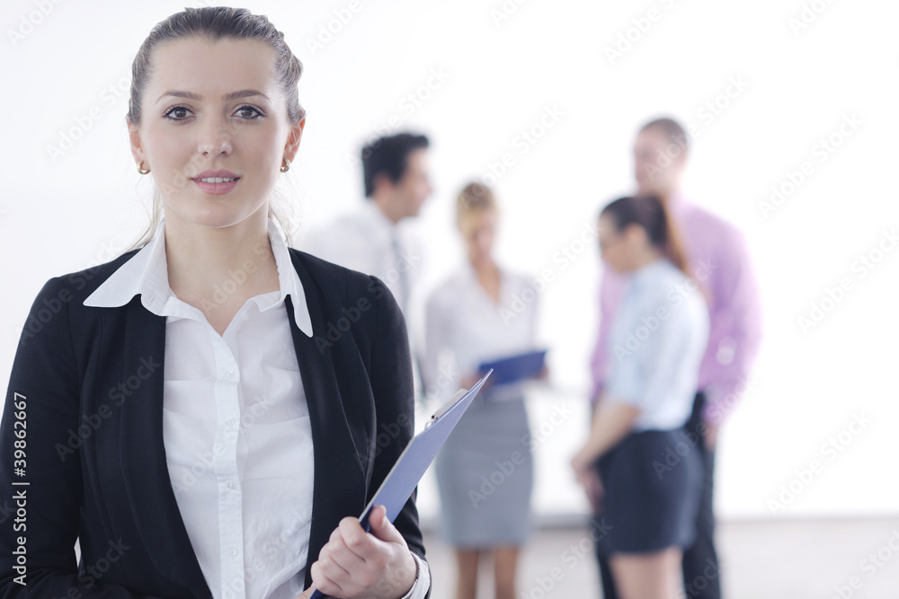 business woman standing with her staff in background business woman standing with her staff in background