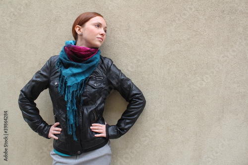 Beautiful redhead young woman near a wall