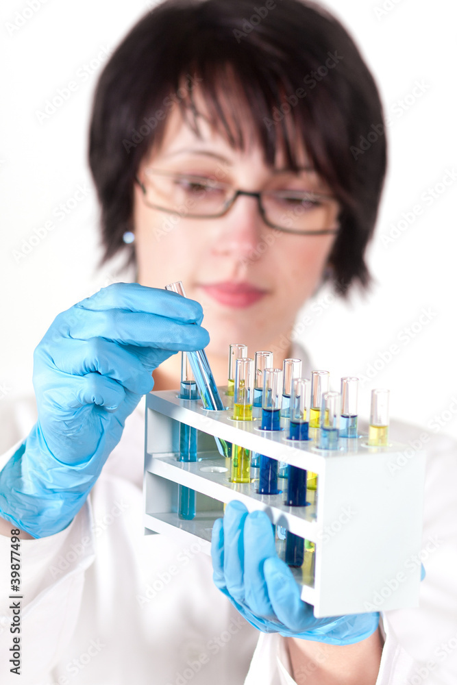 A female scientific researcher looking at a liquid solution. A female scientific researcher looking at a liquid solution.