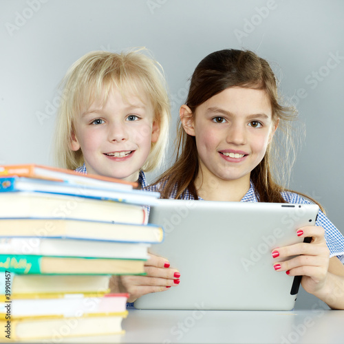 Twogirlfriends learn together with books and touchpad photo