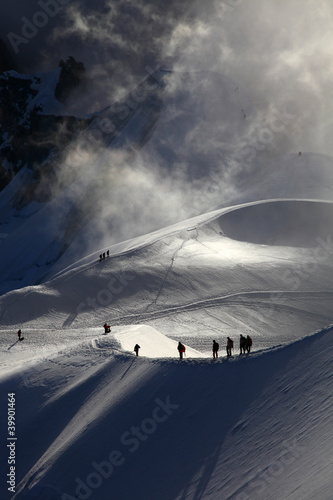 A group of alpinists on their way to the mont blanc at dawn.