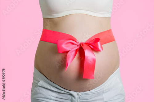 Wallpaper Mural Beautiful young pregnant woman with ribbon. Isolated on pink Torontodigital.ca