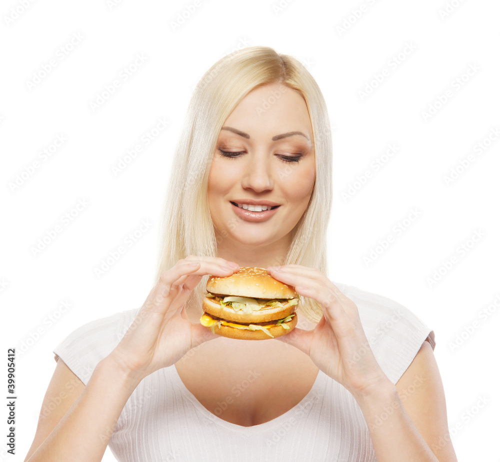 A young blond woman holding a fresh hamburger A young blond woman holding a fresh hamburger