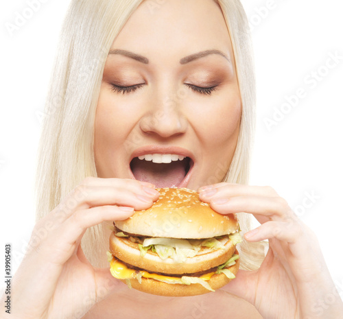 Portrait of a young woman eating a fresh burger