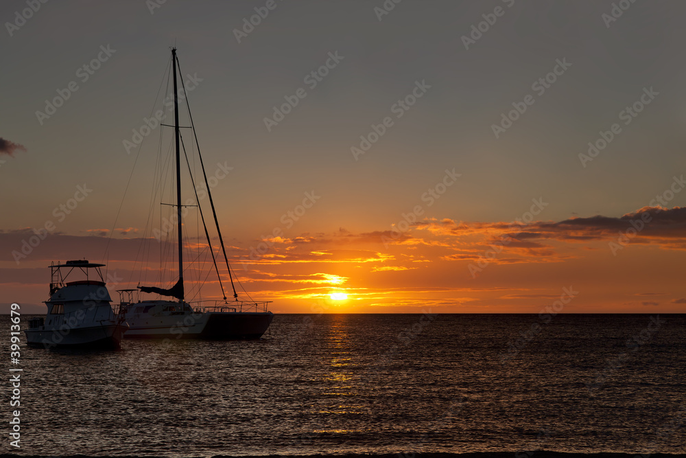 boats moored in a tropical bay at  sunset