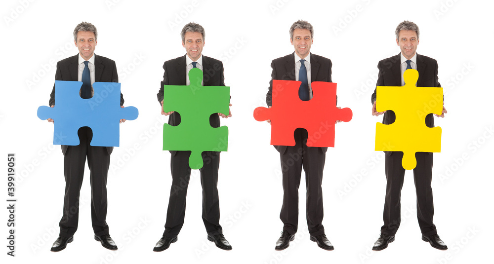 Obraz premium Group of business people holding jigsaw puzzle