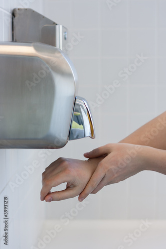 Drying hands in a public restroom (selective focus)