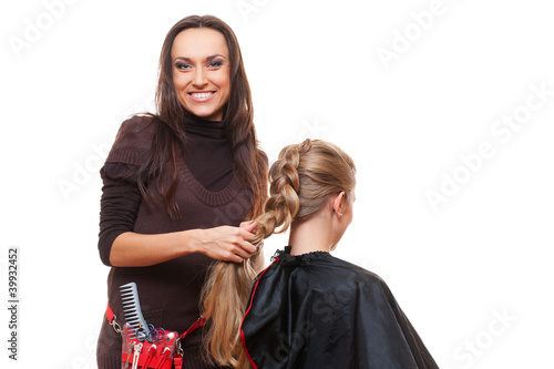 studio shot of smiley hairdresser doing a plait