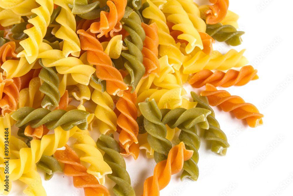 Uncooked pasta fusilli in different colours, white background Uncooked pasta fusilli in different colours, white background