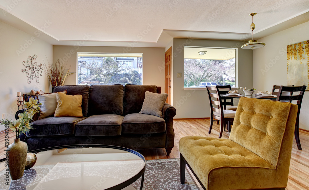 Living room with brown sofa and yellow chair. Living room with brown sofa and yellow chair.