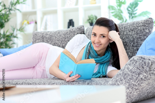 women reading a book on sofa