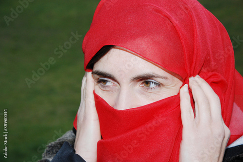woman with her face covered with red scarf