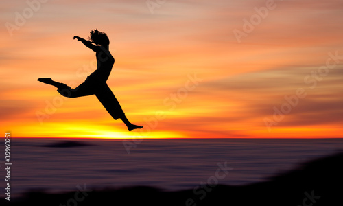 silhouette of girl jumping in sunset