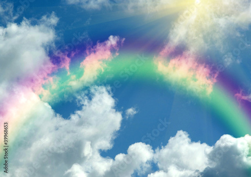 Rainbow in clouds and in blue sky