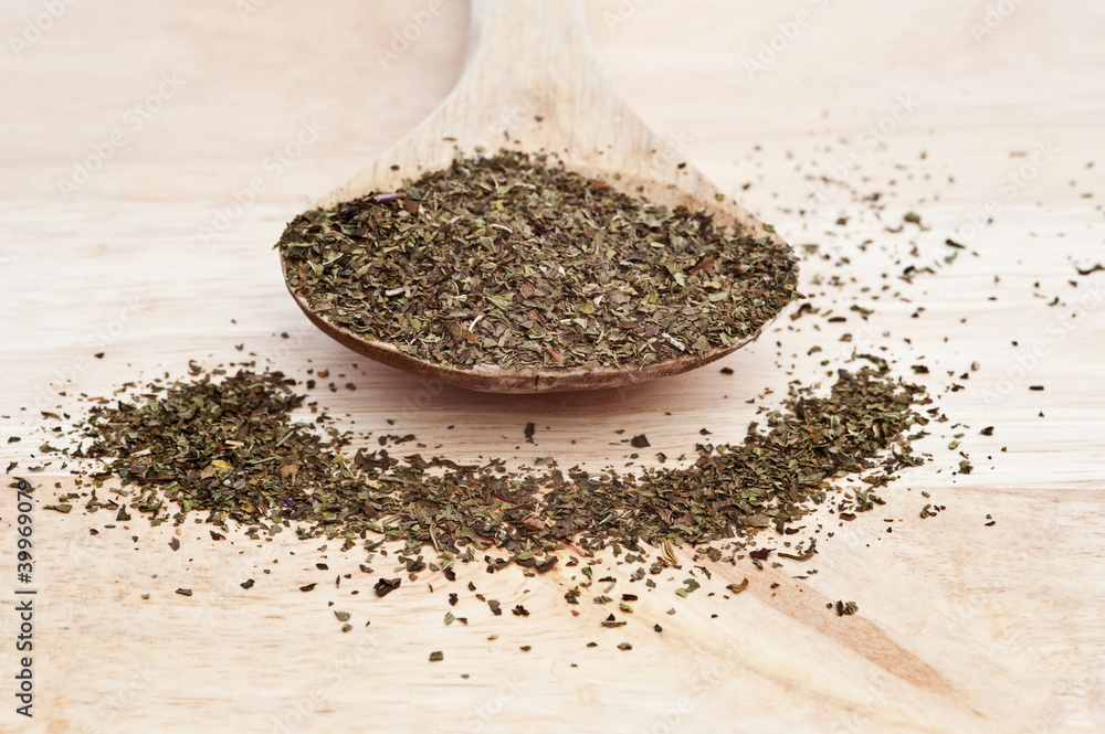 Chopped mint on wooden serving spoon with selective focus Chopped mint on wooden serving spoon with selective focus