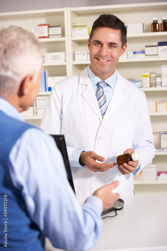© Monkey Business - American pharmacist with senior man in pharmacy