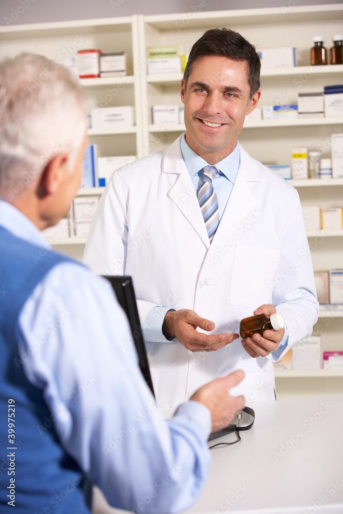 American pharmacist with senior man in pharmacy