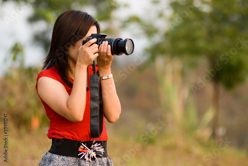 Pretty Asian woman in red dress take a photo .