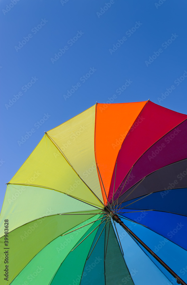 Colorful umbrella on a sky background, vertical view