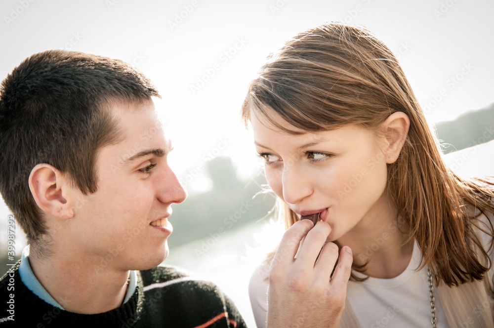 Fototapeta premium Young couple in locve eating chocolate