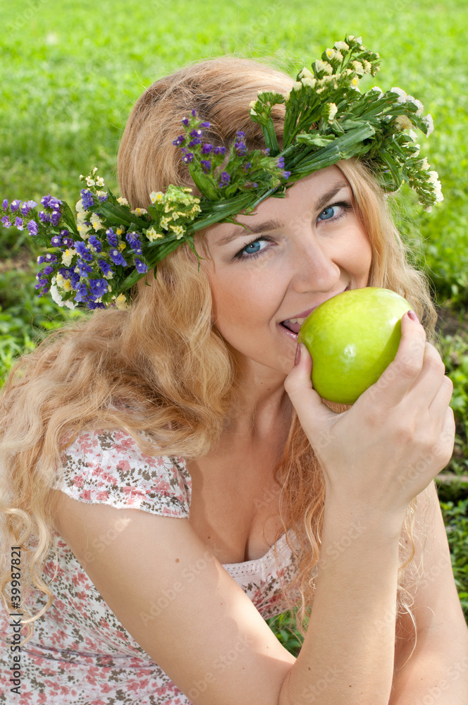 A beautiful blonde young woman with a wreath on his head eating A beautiful blonde young woman with a wreath on his head eating