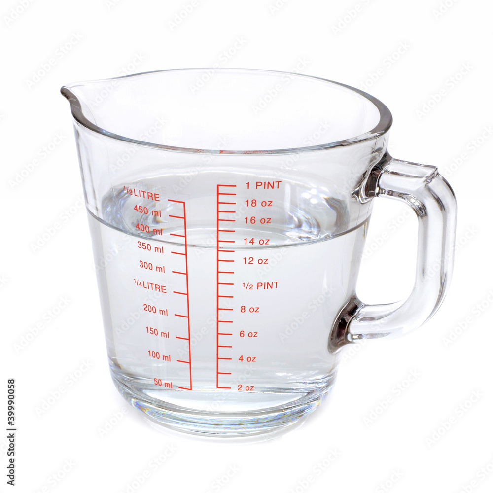 Water in glass measuring cup isolated on white background Photos | Adobe  Stock