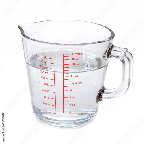 Water in glass measuring cup isolated on white background Photos | Adobe  Stock