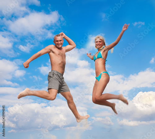 young people jumping in the air against a blue sky