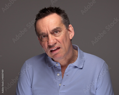 Middle Age Man Pulling Unhappy Face and Grimacing