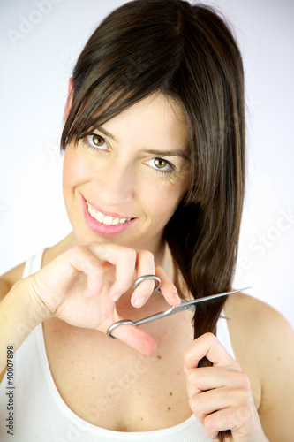 Girl cuts her long hair smiling