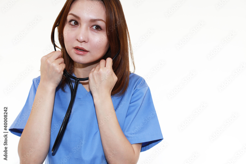 聴診器を耳にあてる女医 聴診器を耳にあてる女医