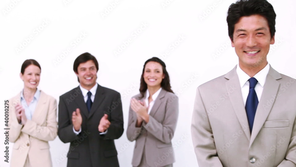 Businessman being congratulated by colleagues Businessman being congratulated by colleagues
